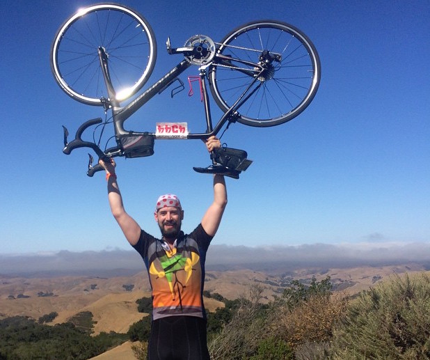 a man holding a bike over his head